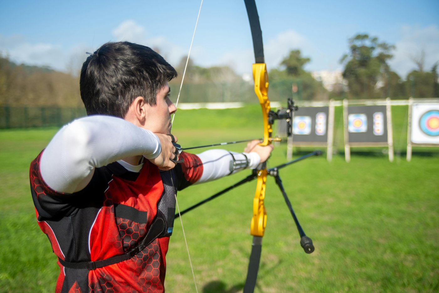 An archer drawing a recurve bow toward a row of targets — aim before you fire